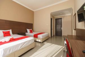 Postel nebo postele na pokoji v ubytování RedDoorz Syariah At Hotel Putri Gading Bengkulu