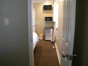 a kitchen with a white refrigerator and a white bed at Beach Walk Hotel in Ocean City
