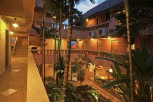 a building with a courtyard with palm trees and lights at Casa Brazil Homestay in Karon Beach