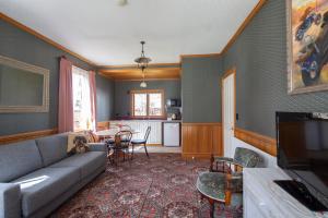 a living room with a couch and a dining room at Settlers Cottage Motel in Arrowtown