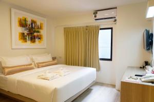 曼谷的住宿－薩瓦斯德酒店，卧室设有一张白色大床和一扇窗户。