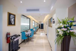 a dining room with tables and blue chairs at Hotel Americano in Garapan