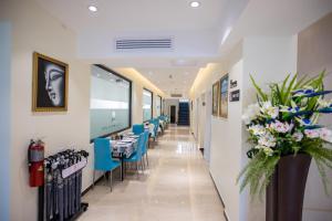 een eetkamer met tafels en blauwe stoelen bij Hotel Americano in Garapan