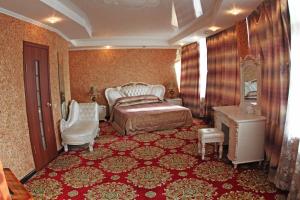 a bedroom with a bed and a chair and a table at Acfes-Seiyo Hotel in Vladivostok