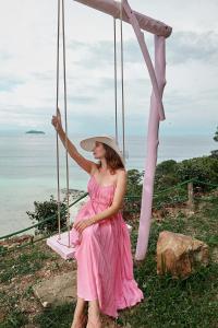 a woman in a pink dress sitting on a swing at Villa 360 in Phi Phi Islands