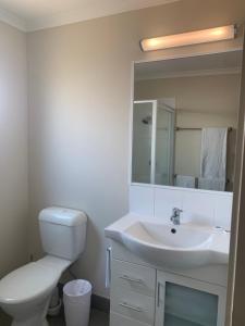 a bathroom with a white toilet and a sink at Horseshoe Bay Resort in Bowen