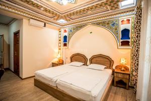 1 dormitorio con cama y techo artesonado en Boutique DEVON, en Bukhara