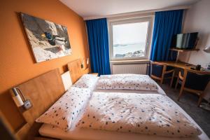 Schlafzimmer mit einem Bett und einem Fenster in der Unterkunft Hotel Panorama Garni in Helgoland