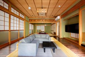 a living room with a couch and a tv at Oyado E-TIME Tamade Annex in Osaka