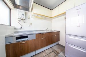 a kitchen with a sink and a stove at Oyado E-TIME Tamade Annex in Osaka