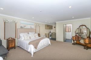 ein Schlafzimmer mit einem großen Bett und einem Spiegel in der Unterkunft Daffodil Bed and Breakfast in Hamilton