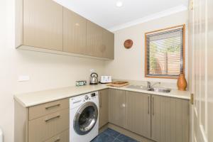 a kitchen with a washing machine and a sink at Daffodil Bed and Breakfast in Hamilton