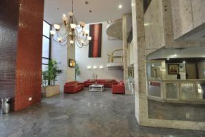 a large lobby with red furniture and a chandelier at Sol Victoria Marina Lofts in Salvador