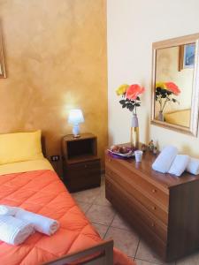ein Schlafzimmer mit einem Bett und eine Kommode mit einem Spiegel in der Unterkunft B&B Salerno in Sarno