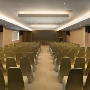 une salle de conférence vide avec des chaises et un podium dans l'établissement Aryaduta Palembang, à Palembang