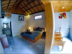 1 dormitorio con 1 cama y 1 silla en una habitación en Santai Bungalow, en Gili Trawangan