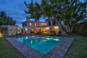 a large swimming pool in front of a house at Nova Constantia Boutique Residence in Cape Town