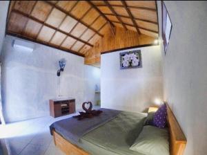 Un dormitorio con una cama con una cinta. en Santai Bungalow, en Gili Trawangan