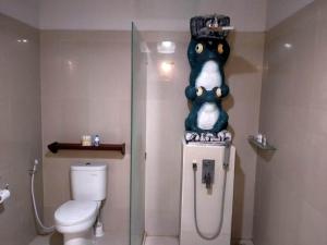 a bathroom with a toilet and a shower with a dog on the wall at Puri Mas Boutique Resort & Spa in Senggigi