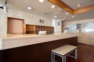 a bar in a restaurant with a counter and a stool at Hotel Econo Higashi Kanazawa in Kanazawa