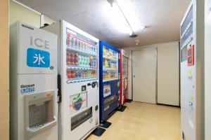 a convenience store aisle with refrigerators and machines at Hotel Econo Higashi Kanazawa in Kanazawa