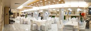 a banquet hall with white tables and white chairs at Plaza Hotel Plovdiv - Free Parking in Plovdiv +74 photos
