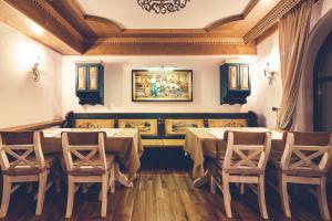 a dining room with two tables and chairs and a painting at Casa Comana Boutique Hotel in Bucharest