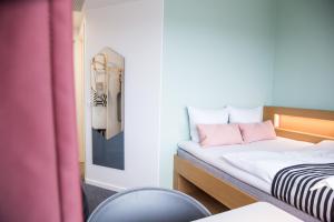 a room with two beds with a mirror and a chair at Comwell Aarhus Dolce by Wyndham in Aarhus
