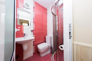 a red bathroom with a toilet and a sink at Family Hotel Madrid in Sofia +71 photos