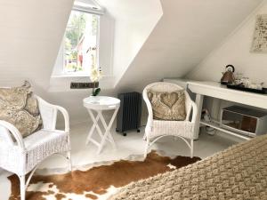a bedroom with two chairs and a desk and a bed at Drewry Lane in Howick