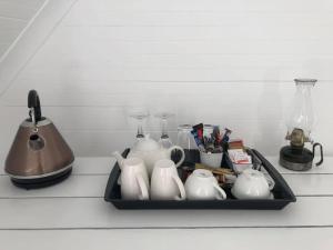 a tray with tea pots and utensils in a kitchen sink at Drewry Lane in Howick