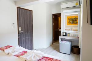 a white room with two beds and a bathroom at Sawasdee House in Bangkok