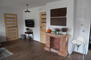 a living room with a brick fireplace and a television at Gołubski Loft in Gołubie