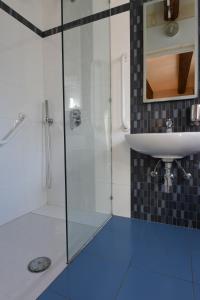 a bathroom with a glass shower and a sink at Maria Giovanna Guest House in Marsalforn