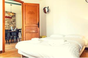sypialnia z 2 białymi łóżkami i stołem w obiekcie Le Courbet Topdestination-dijon - Centre ville - Classé 3 étoiles w mieście Dijon