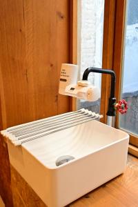 a white sink sitting on a wooden counter with aounter at Kawaramachi Domitory in Takamatsu