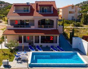 ein Haus mit einem Pool vor einem Haus in der Unterkunft Villa Second-Home in Ražanj