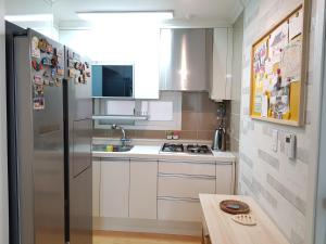 a small kitchen with a stainless steel refrigerator at Comfortable as your home - JS1 in Seoul