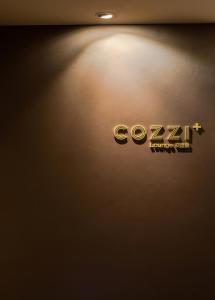 un primo piano di un logo aziendale su un muro di Hotel COZZI Ximen Tainan a Tainan