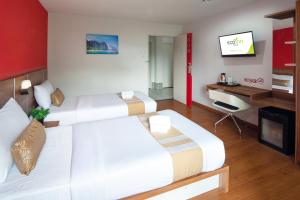 a hotel room with two beds and a tv at Eco Inn Prime Trang in Trang