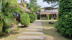 um jardim com um caminho de pedra que leva a uma casa em Popular Lanta Resort em Ko Lanta