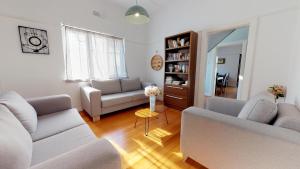 a living room with two couches and a table at Port View Guest House in Cape Town