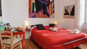 ein rotes Bett in einem Zimmer mit einem Tisch und einem Stuhl in der Unterkunft B&B Villa Musa in Rom