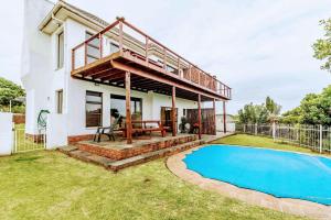 a house with a deck and a swimming pool at Cove View B&B in East London