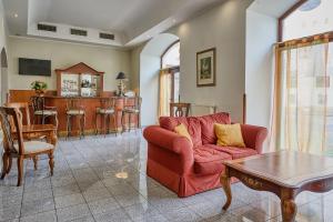 sala de estar con sofá rojo y mesa en Hotel Royal, en Chomutov