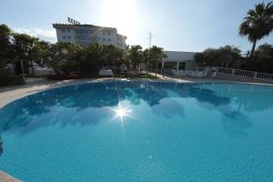 une grande piscine bleue en face d'un bâtiment dans l'établissement Edra Palace Hotel & Ristorante, à Cassino