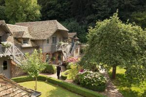 Un uomo in piedi nel cortile di una casa di La Ferme Saint Simeon Spa - Relais & Chateaux a Honfleur