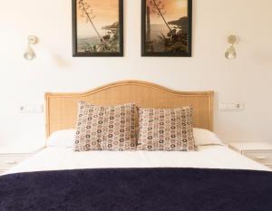 デニアにあるApartamentos Villamorのベッド1台(枕2つ、壁に3枚の写真付)