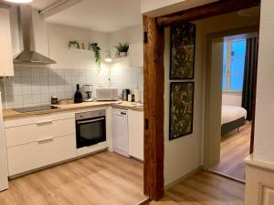 科尔马Appartements des 2 Têtes的一间厨房,配有白色的橱柜和一张位于客房内的床