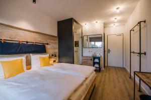 ein Schlafzimmer mit einem großen weißen Bett mit gelben Kissen in der Unterkunft Hotel Landhafen in Niebüll